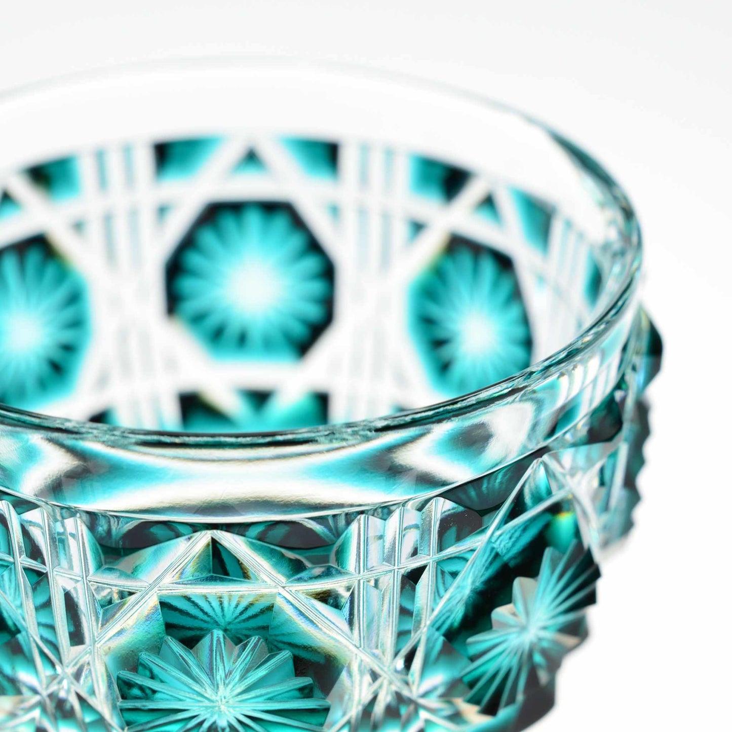 Close-up of green Satsuma Kiriko sake cup highlighting craftsmanship and intricate patterns.