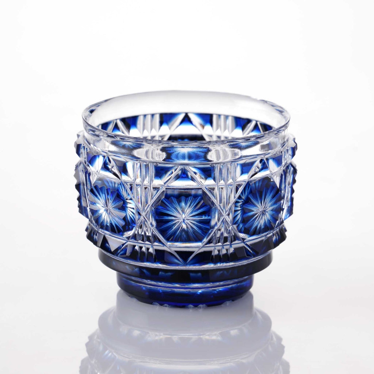 Indigo Satsuma Kiriko sake cup with traditional geometric and starburst designs.