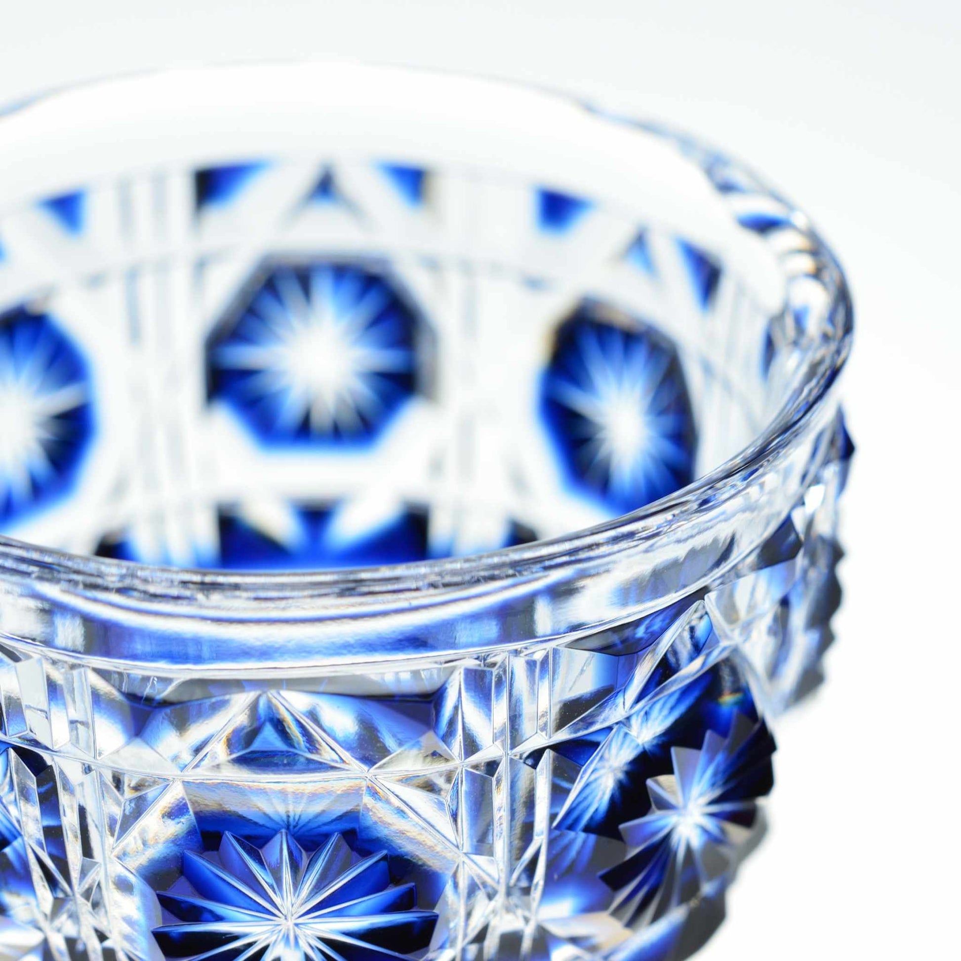 Close-up of indigo Satsuma Kiriko sake cup showcasing craftsmanship and deep blue tones.