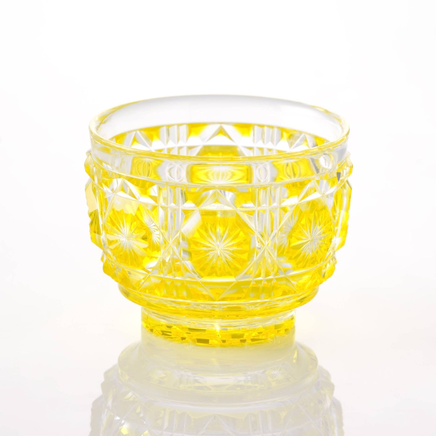 Satsuma Kiriko yellow sake cup with traditional starburst and geometric patterns.