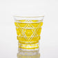 Full view of a Satsuma Kiriko two-tone yellow sake glass, reflecting intricate patterns and craftsmanship.