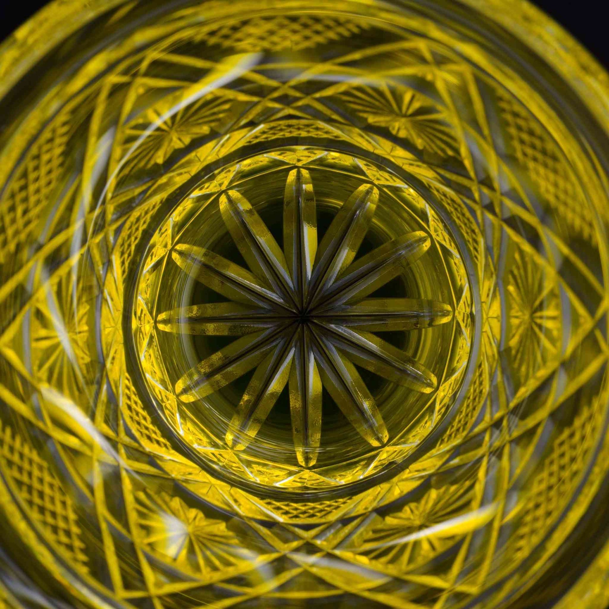 Top view of a Satsuma Kiriko two-tone yellow sake glass, intricate star pattern etched inside.