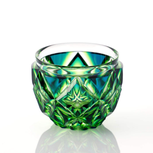 Cyan yellow green Satsuma Kiriko two-tone sake cup, elegantly reflecting light with a complex geometric pattern.