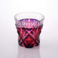 Satsuma Kiriko two-tone sake cup with geometric red and purple patterns against a reflective surface.