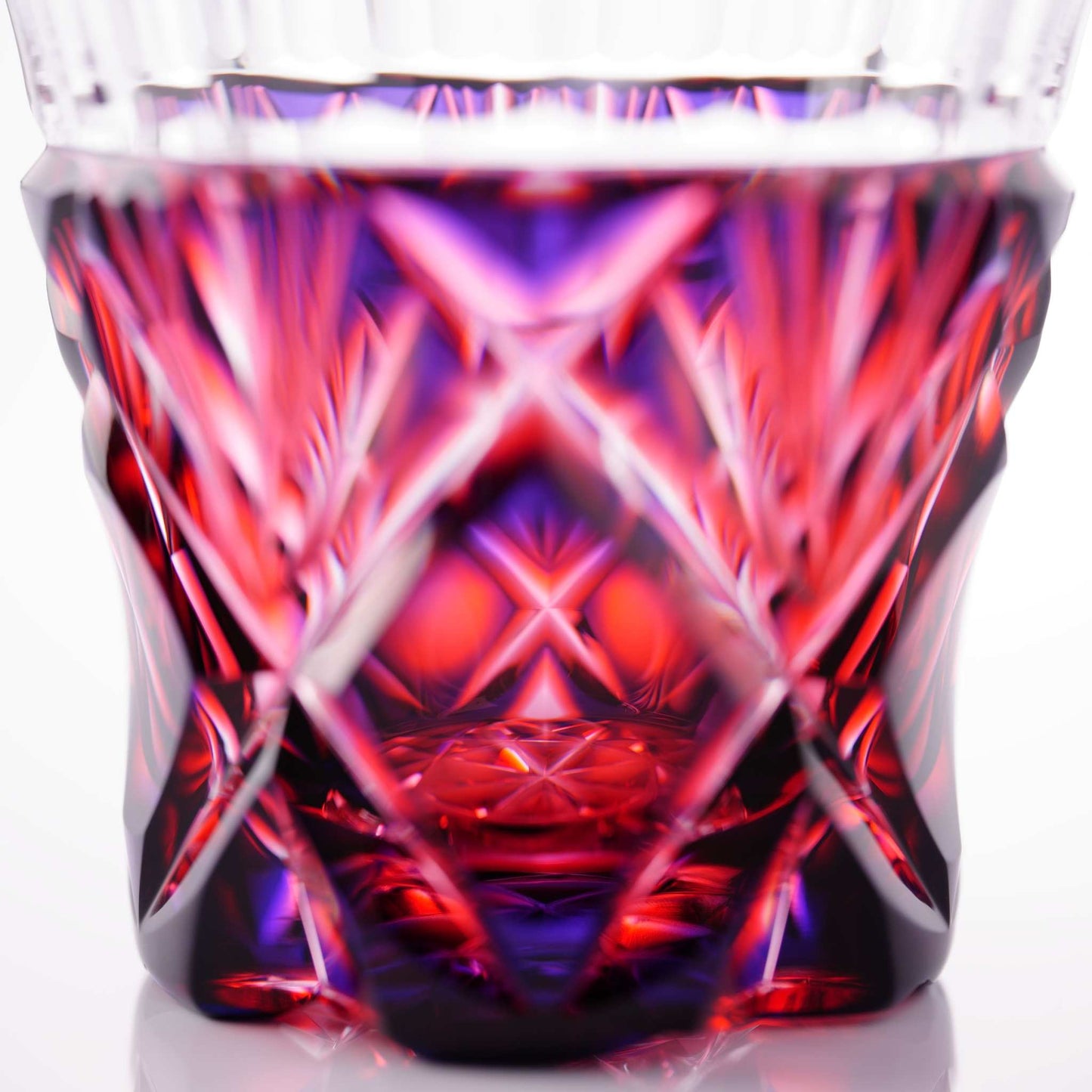 Detailed cut glass pattern on Satsuma Kiriko two-tone sake cup, highlighting its brilliant red and purple tones.