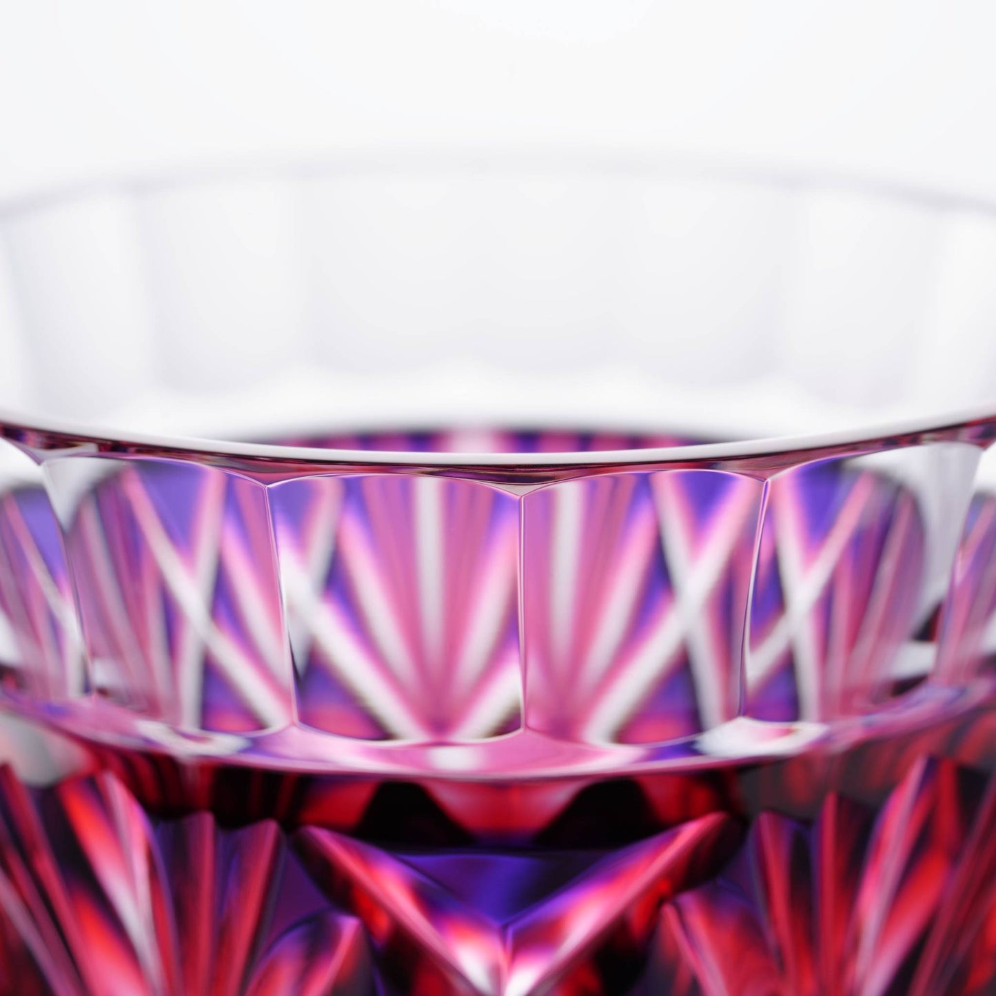 Close-up of Satsuma Kiriko two-tone sake cup showing detailed cut glass design with red and purple accents.