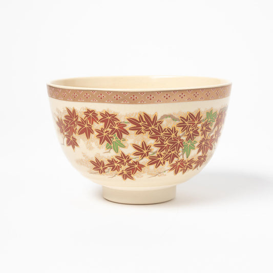 Profile view of a matcha bowl featuring a striking design of red maple leaves and a patterned rim, reflecting traditional Japanese artistry.