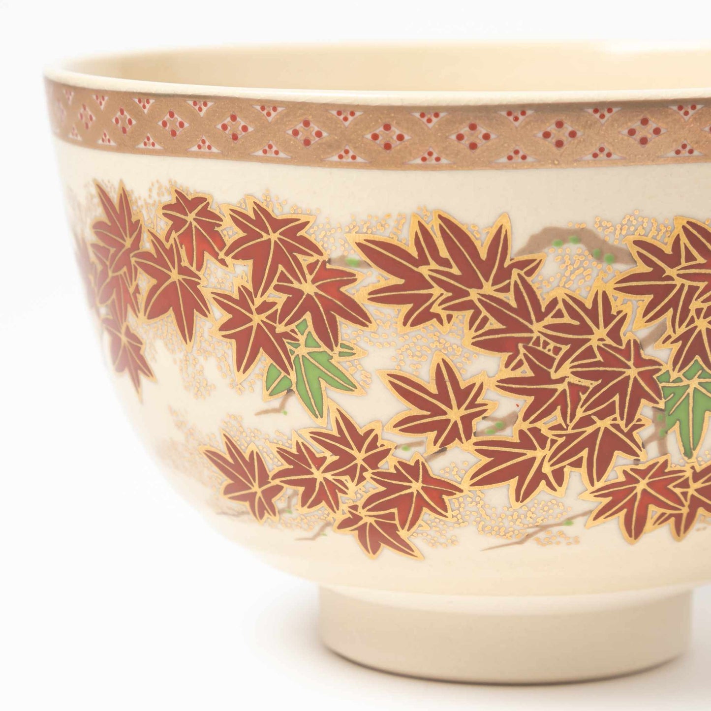 Close-up of the detailed red and green maple leaves hand-painted on the matcha bowl, highlighting the intricate craftsmanship.