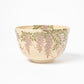 Profile view of a matcha bowl with elegant wisteria floral designs, emphasizing the delicate balance of colors and craftsmanship.