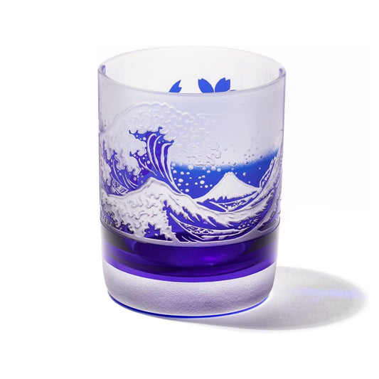 a blue and white whiskey glass with an intricate design of Mount Fuji and a crashing wave, inspired by Japanese art.