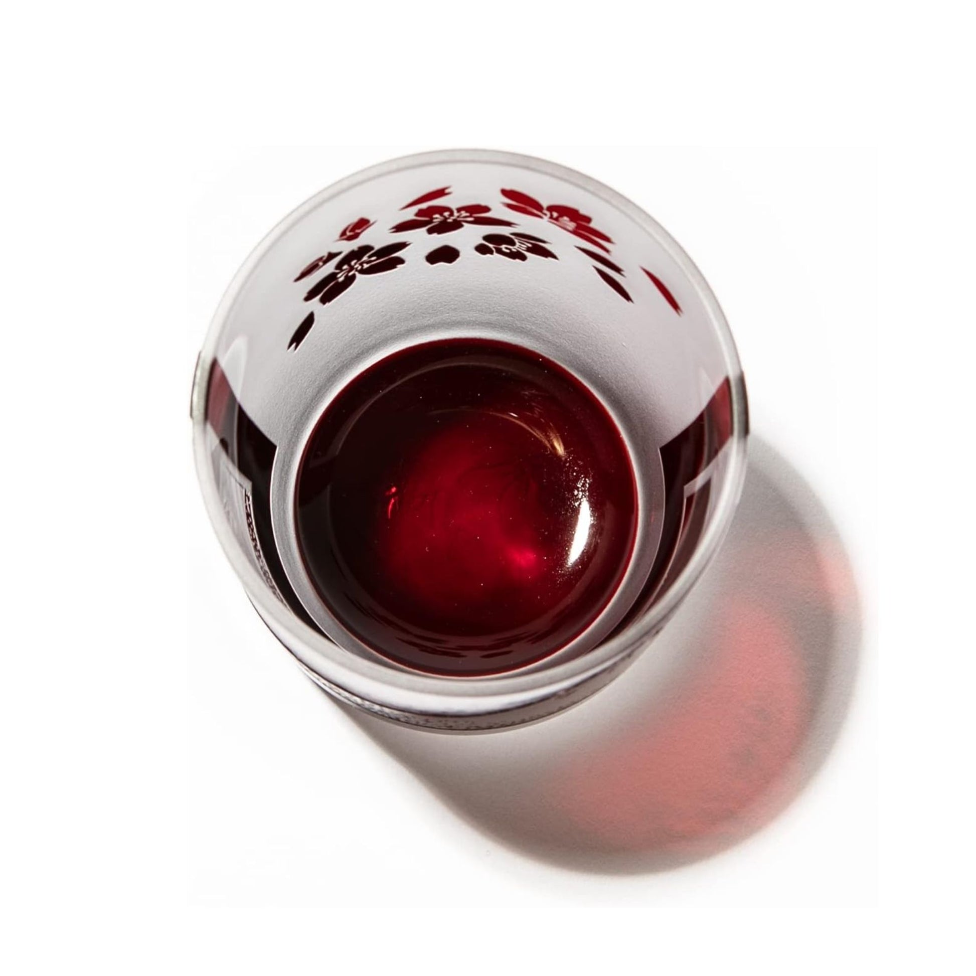 Overhead view of the whiskey glass, highlighting the deep red interior and sakura pattern.