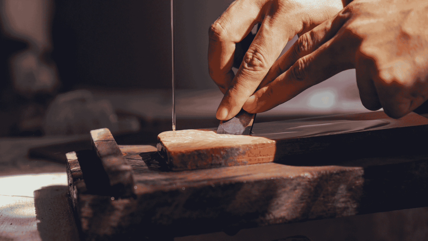 A wood working scene of a hand scraping wood - Omakase 