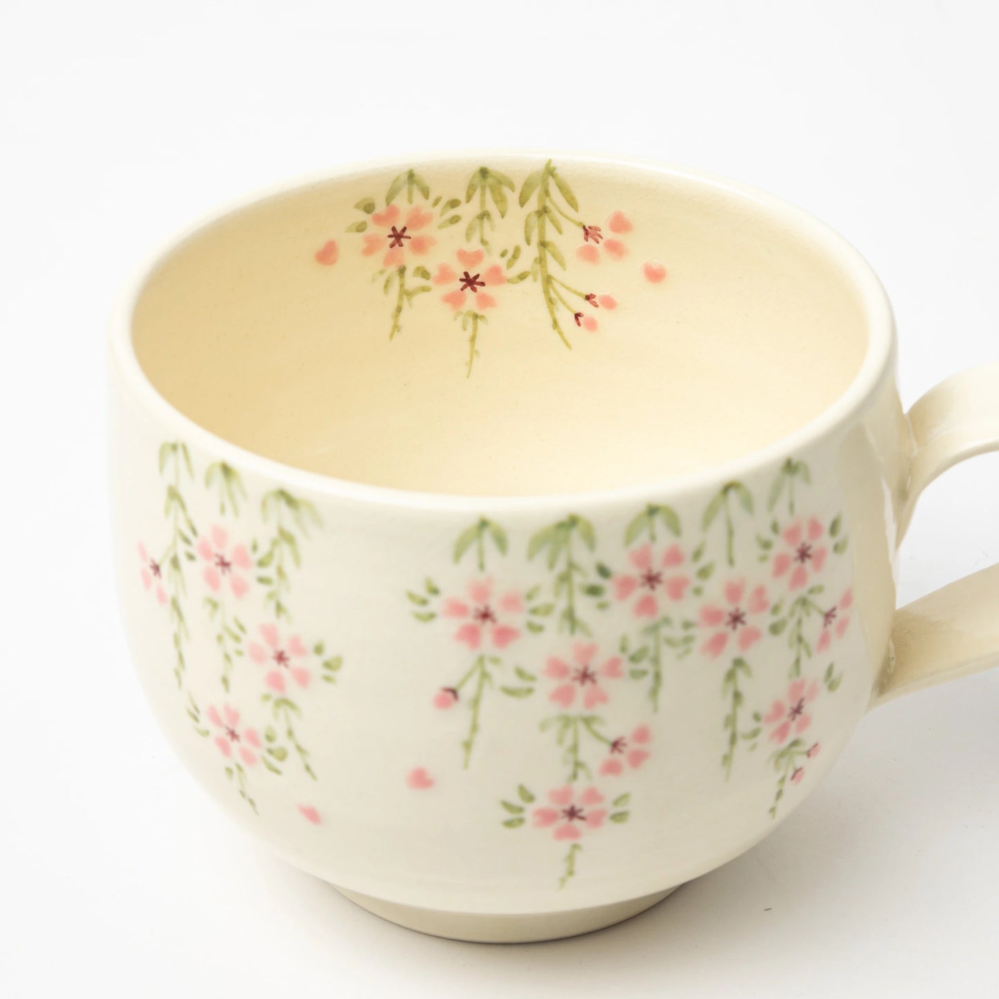 Close-up of the Gion Sakura Café au Lait Mug’s interior, showcasing subtle cherry blossom illustrations inside the cup.