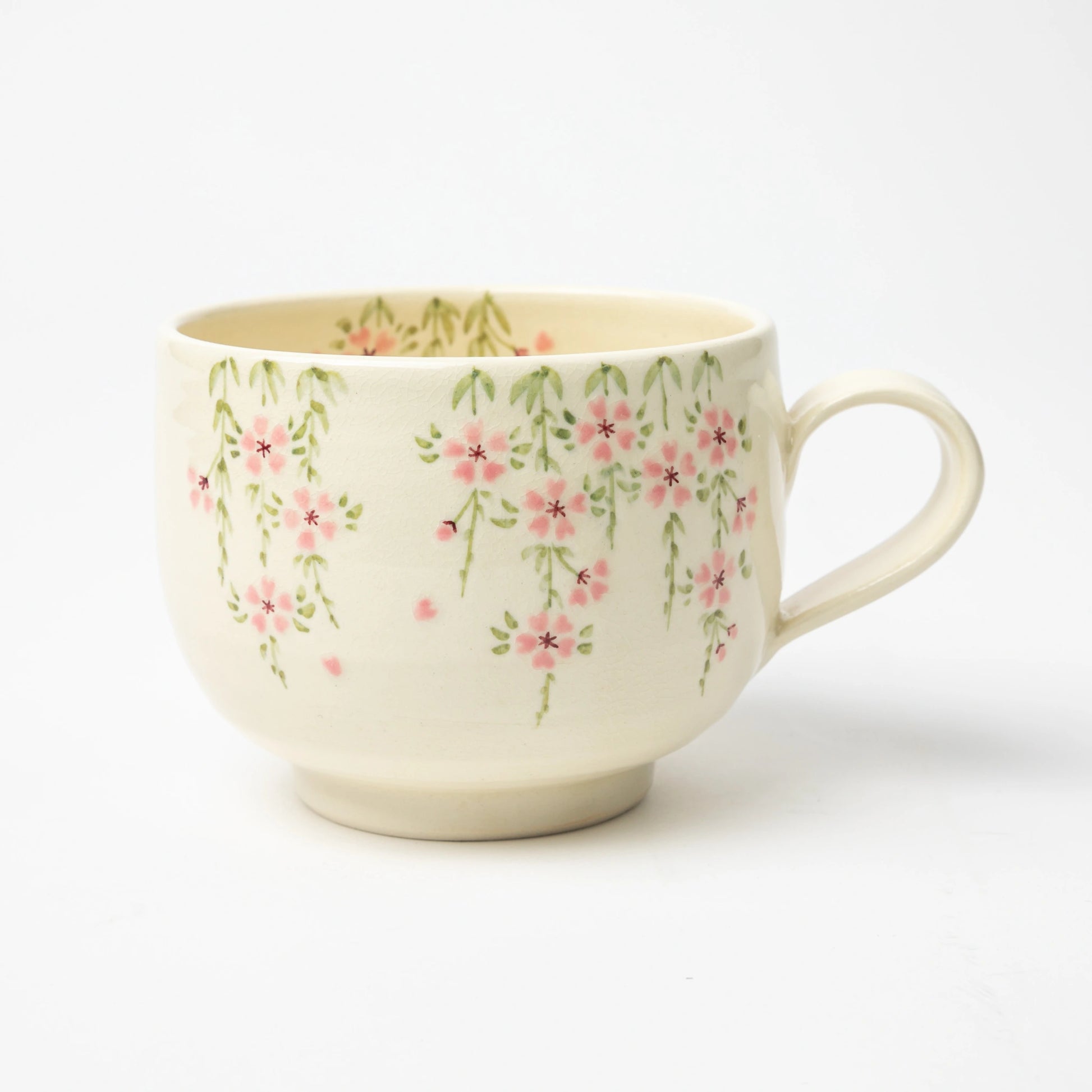 A handcrafted Gion Sakura Café au Lait Mug by Tosen Kiln, featuring delicate pink cherry blossoms cascading over an ivory ceramic surface.