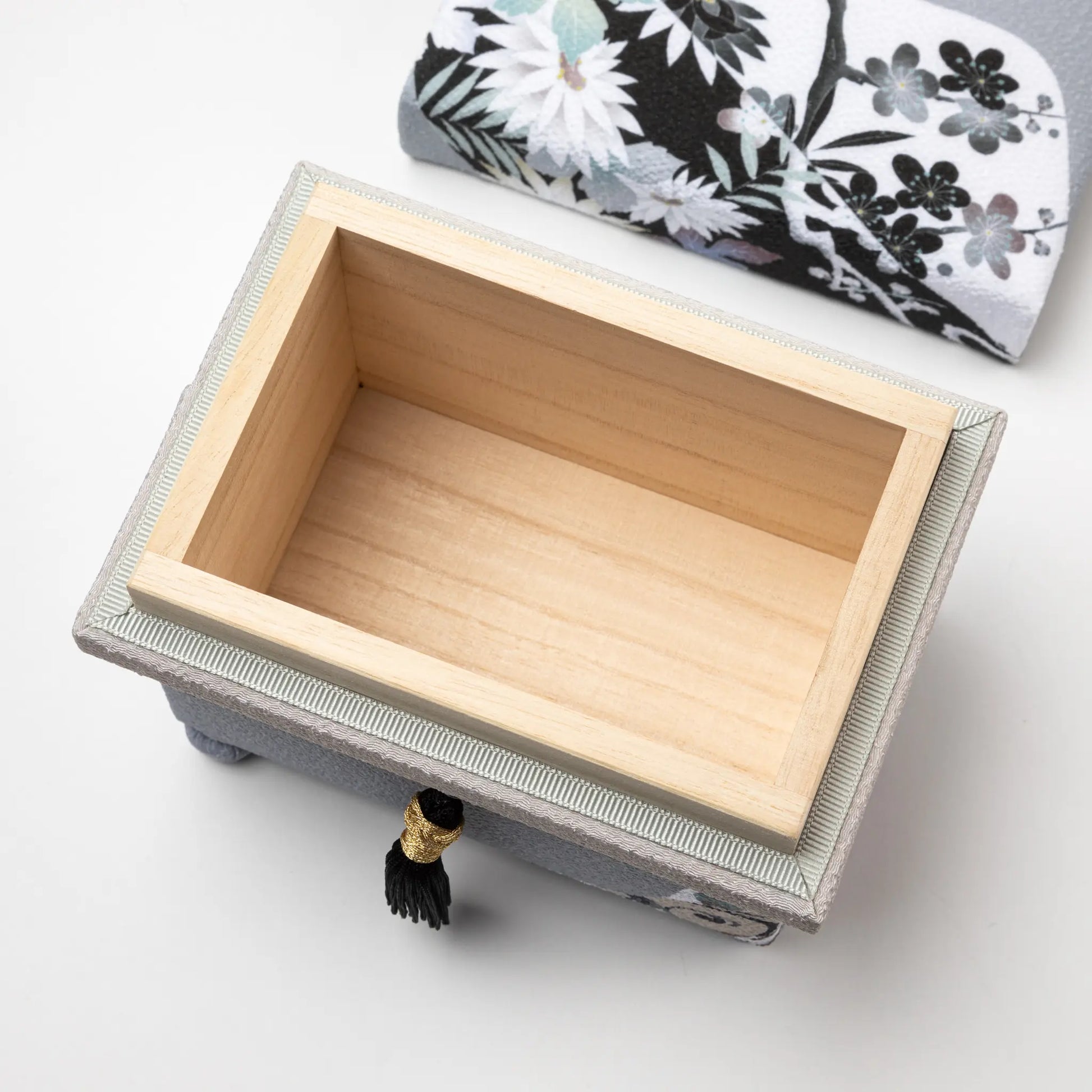 Close-up of the Kaga Yuzen Michinaga Accessory Box interior, with a spacious wooden compartment for storage and the floral-patterned lid in the background.