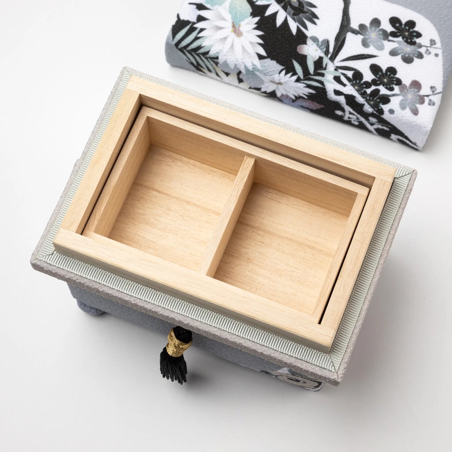 Kaga Yuzen Michinaga Accessory Box with an open lid showcasing a wooden compartment interior, featuring elegant black floral patterns and a black tassel detail.