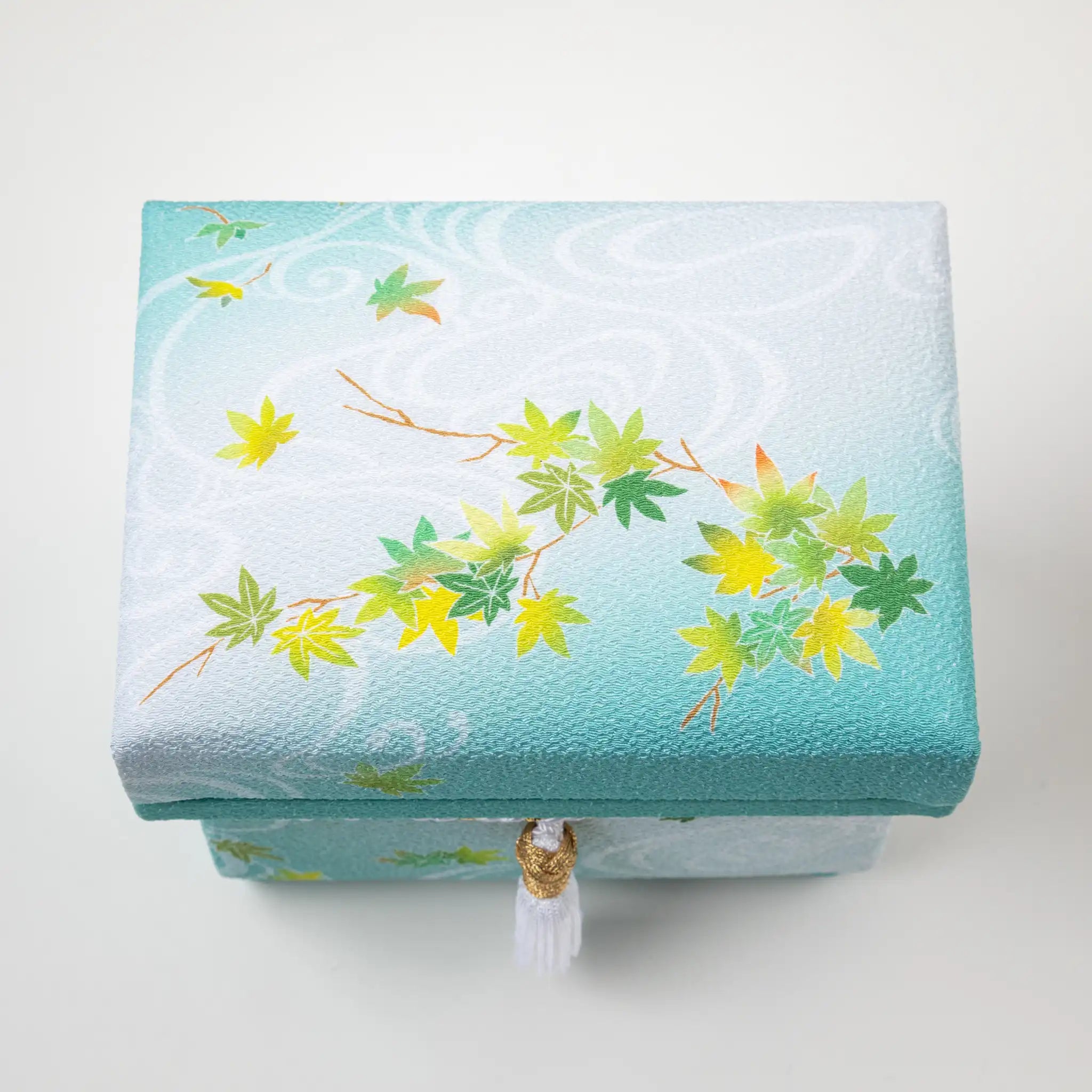Top view of the Kaga Yuzen Maple Leaf Accessory Box, featuring an elegant pattern of maple leaves in green and yellow shades on a light mint green fabric background.