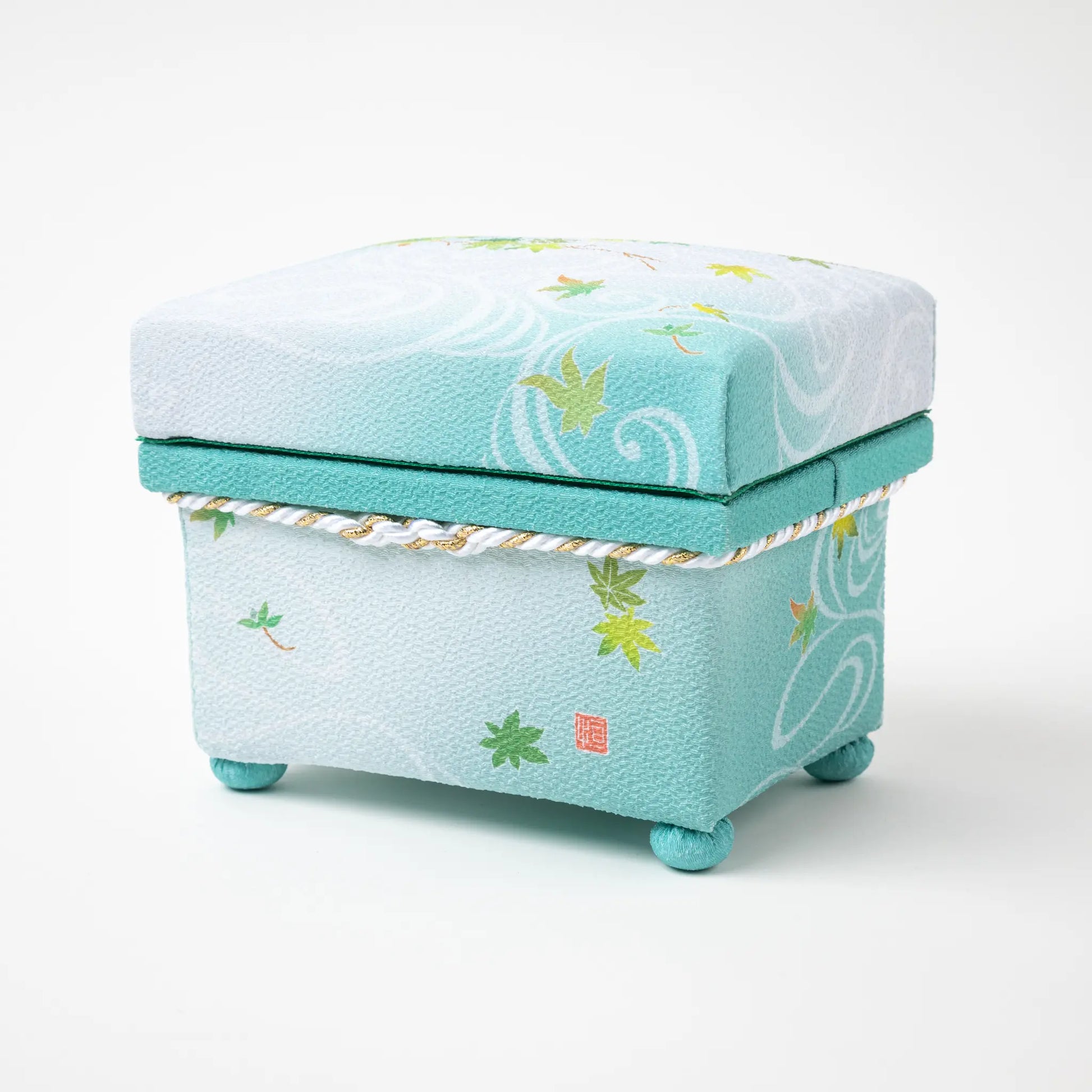 Side view of the Kaga Yuzen Maple Leaf Accessory Box, showcasing its intricate maple leaf designs on a mint green background with a traditional Japanese seal.