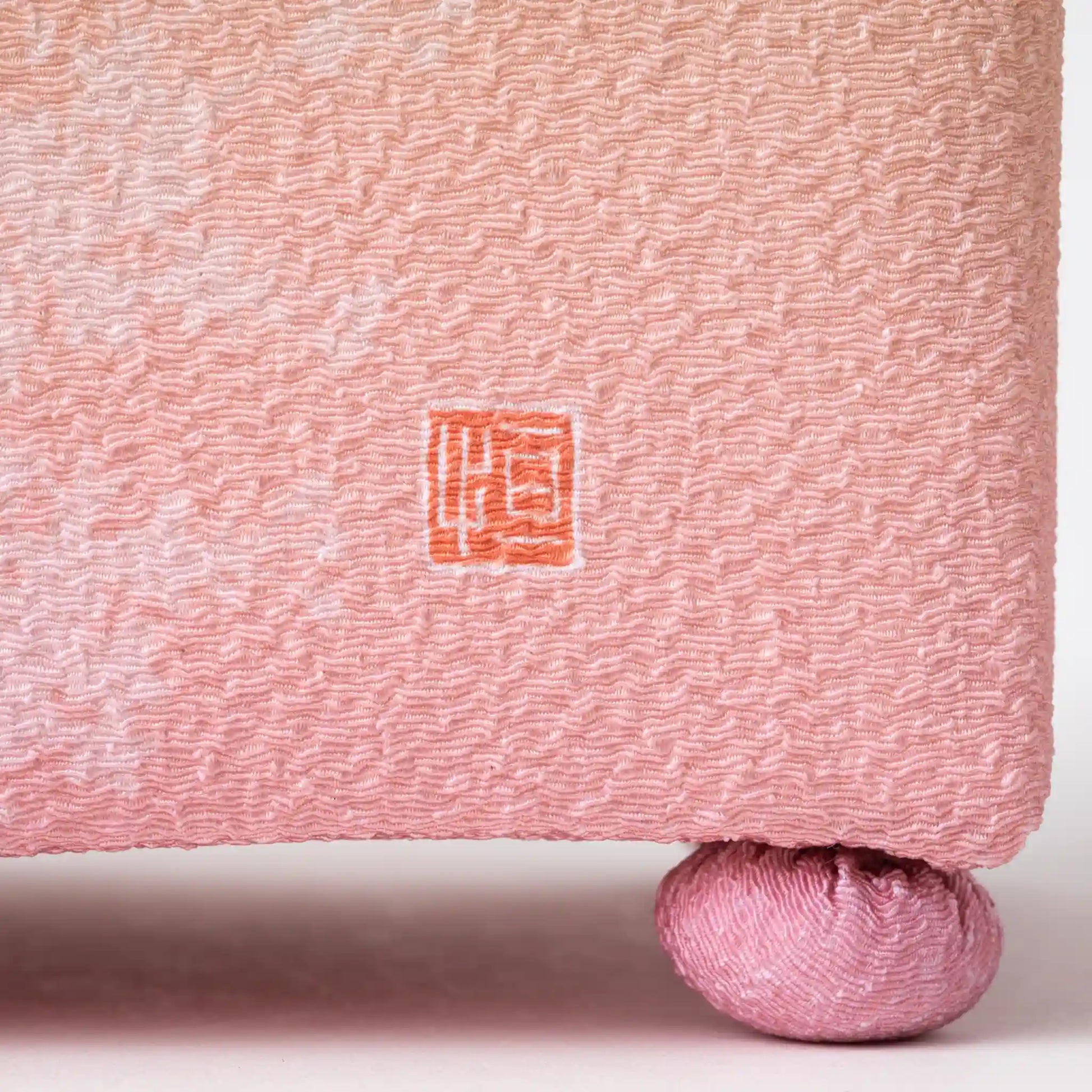 Close-up of the hisatsune YUZEN Kaga Yuzen Sakura accessory box showing intricate sakura patterns and the hisatsune brand mark in red on the pink fabric.